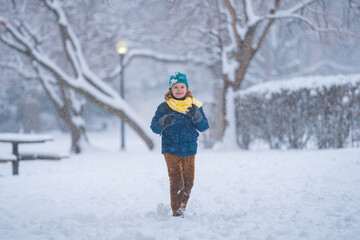 Kid walking through snow with winter happiness. Child walk outdoors in snowfall feels free. Child in warm clothes walking in winter park. Child walk in snow outdoor.