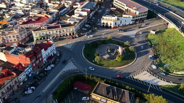 Amazing panoramic drone orbit around the Monumento al Toreo iconic statue and urban roundabout with traffic, Camas, Sevilla, Spain