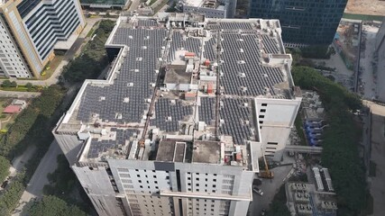 Bird’s-eye drone shot of a metropolitan neighborhood bulding filled with solar panels that produce solar energy