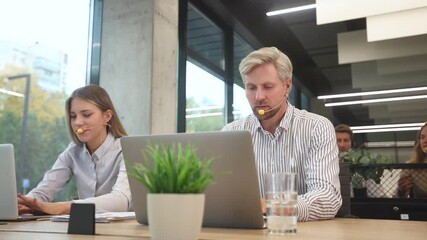 Customer service representatives engaged in professional work using headsets and laptops