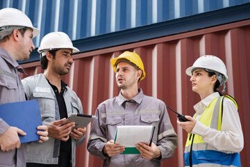 Engineer and worker team working in logistic terminal of container cargo, Diverse construction team in safety gear outdoors