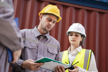 Engineer and worker team working in logistic terminal of container cargo, Diverse construction team in safety gear outdoors