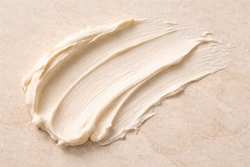 Elegant Swirl: An artistic smear of creamy substance gracefully rests, highlighting texture and form, a symphony of delicate lines and subtle shades on a smooth background.