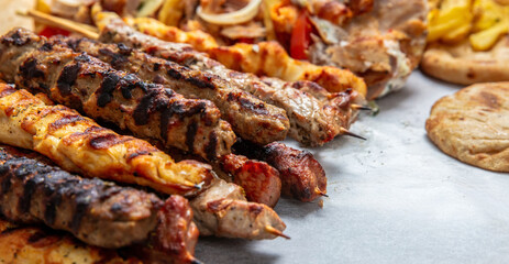 Mixed grilled meat platter, pork and chicken meat skewers, kebab pieces, closeup