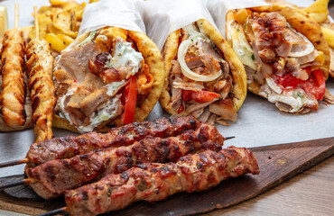 Gyro sliced meat pita bread wraps, pork souvlaki skewers, traditional street food, closeup