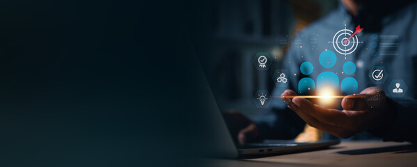 Businessman use a laptop to target and select key personnel using digital technology. The image conveys an HR strategy focused on finding the right employees to drive the organization towards future s