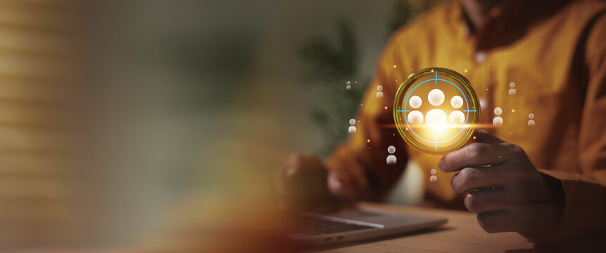 Businessman  selecting and defining the target audience or human resources using digital technology. The glowing scope focuses on a group of people, symbolizing precision in marketing strategy, HR man
