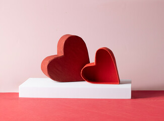 Two red hearts rest side on a pink background, symbolizing romance, passion, and the magic of Valentine's Day love. Festive greeting card