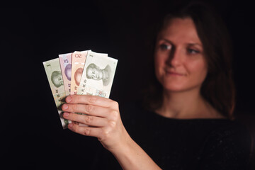 Woman holding chinese yuan renminbi banknotes. Financial concept of money, investment, currency exchange, economy, and saving for international business.