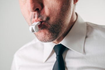 Whistleblower concept, close-up of a businessman blowing a whistle, symbolizing ethics, accountability, and reporting misconduct in corporate or professional environments.