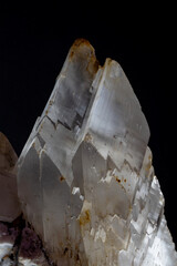 A detailed macro shot of white translucent gypsum crystals showing sharp vertical cleavage planes and natural geometric structures against black background