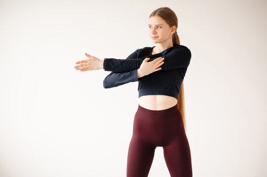 Gir stretching her arms and shoulders in a fitness studi