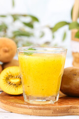 Fototapeta premium Fresh Yellow Kiwi Juice Still Life with Fruit