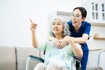 Obraz premium Asian caregiver doctor examine older patient woman therapist nurse at nursing home taking care of senior elderly woman sit on sofa.Medical service concept.