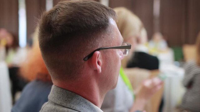 Minsk, Belarus 20.09.23: Business lunch exhibition marketing. Men at table audience at business conference listening to speaker