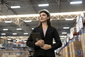 Confident female warehouse manager standing with tablet in storage facility, symbolizing leadership, modern logistics management import export shipping.