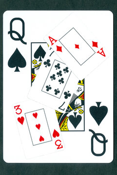 Playing cards: three of hearts, seven of clubs and ace of diamonds against the background of the Queen of Spades.