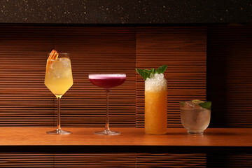 Variety of Four Colorful Craft Cocktails on a Wooden Bar