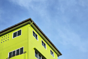 Bright Lime Green Building Corner Against Blue Sky.