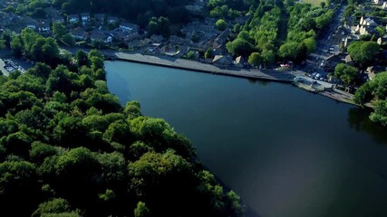 Cinematic aerial flight over lake and landscape towards the Newmillerdam war memorial