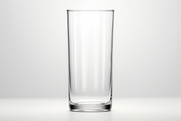 Empty transparent tall highball glass standing on a clean white surface with copy space