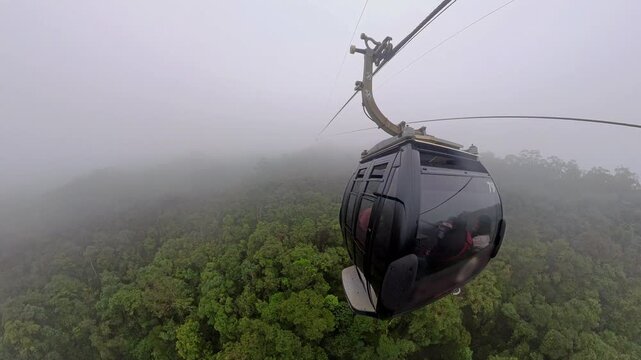 Cable Car Emerging from Heavy Mist Above Forest during Ascent to Bana Hills in Wide Angle Aerial View