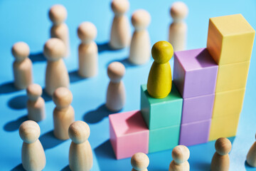 Wooden figurine climbing up the success steps.