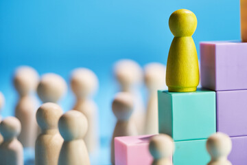 Wooden figurine climbing up the success steps.