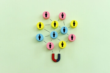 Concept image of a magnet attracting a group of people. metaphor of media influence and human resources