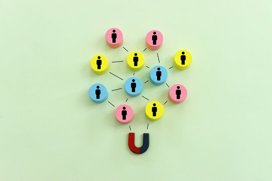 Concept image of a magnet attracting a group of people. metaphor of media influence and human resources