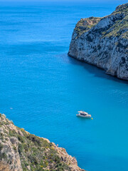 Recreational boat anchored in the cove of Cala de la Granadella in Alicante, Spain