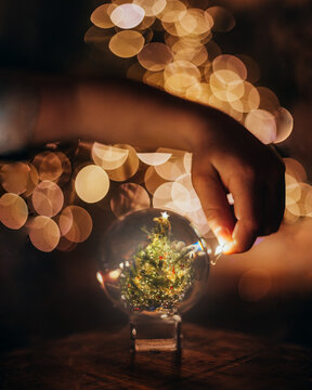 Hand Holding Lights around Glass Ball