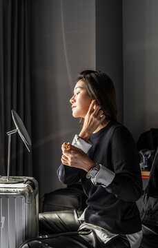 Woman using her suitcase as a makeshift make up table