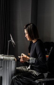 Woman using her suitcase as a makeshift make up table