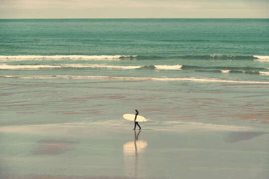 Surfer Walking Out to Sea on Oregon Coast