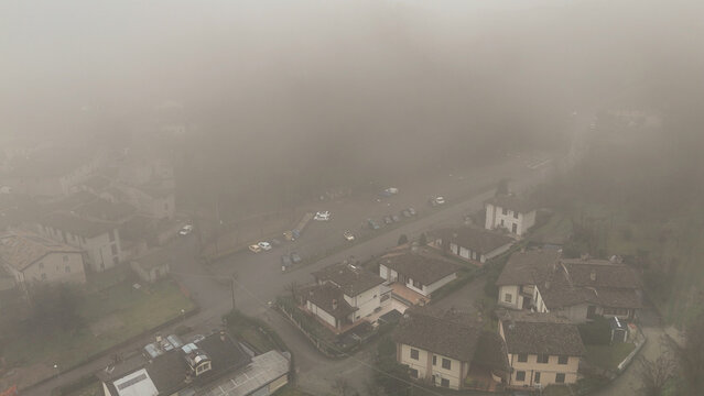 Castell'Arquato village shrouded in thick winter fog, aerial view