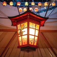 Illuminated pagoda-style lantern, ornate design, with colorful hanging lights