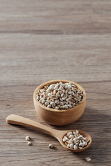Natural Organic Grains in Wooden Bowl and Spoon on Rustic Table