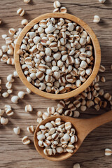 White grains in wooden bowl and spoon on rustic wooden table