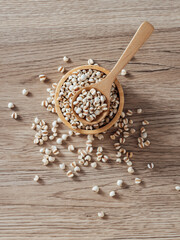Organic Grains in Wooden Bowl with Spoon on Natural Surface
