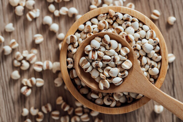 Organic Grains in Wooden Bowl with Spoon on Rustic Wooden Surface