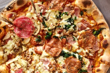 Traditional Pepperoni pizza with mozarella and basil on wooden board.