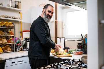 Professional chef is preparing meal in restaurant's kitchen. He makes a vegetarian lunch.
