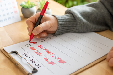 Hand marking a checklist box on a to-do list featuring work harder and work smarter concepts, symbolizing choice, productivity, and an executive decision for business strategy