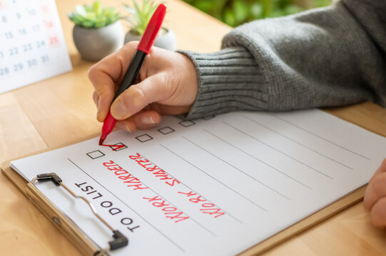 Hand marking a checklist box on a to-do list featuring work harder and work smarter concepts, symbolizing choice, productivity, and an executive decision for business strategy