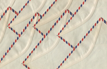 Vintage airmail envelopes arranged in a repeating pattern forming a textured postal paper background