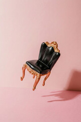 Miniature dollhouse furniture antique chair floating with a soft shadow on pink backdrop.