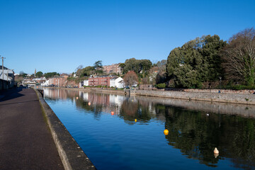 Obraz premium Exeter Quay on a winters day. Blue sky and mirror flat water. Looking towards the city centre. 