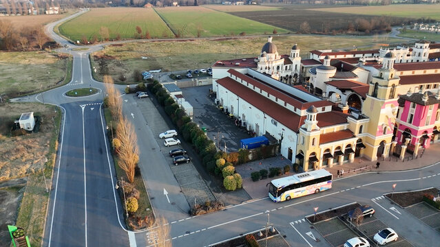 Aerial view of Fidenza Village shopping outlet with a bus arriving and surrounding landscape