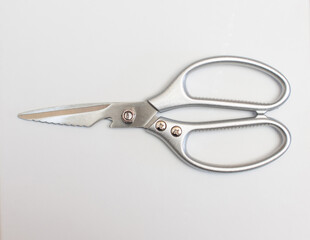 Stainless steel scissors are placed on a white surface.